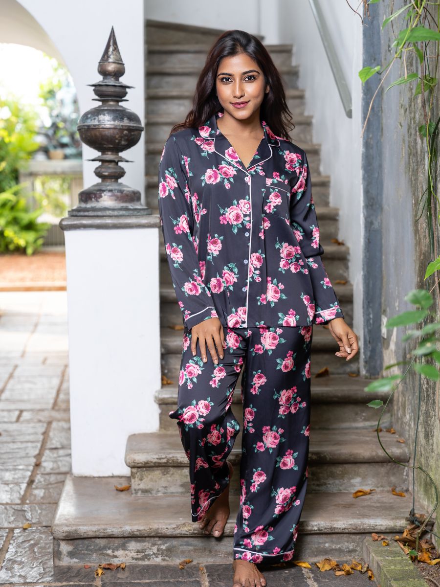 Woman wearing a floral pajama set standing on outdoor steps.