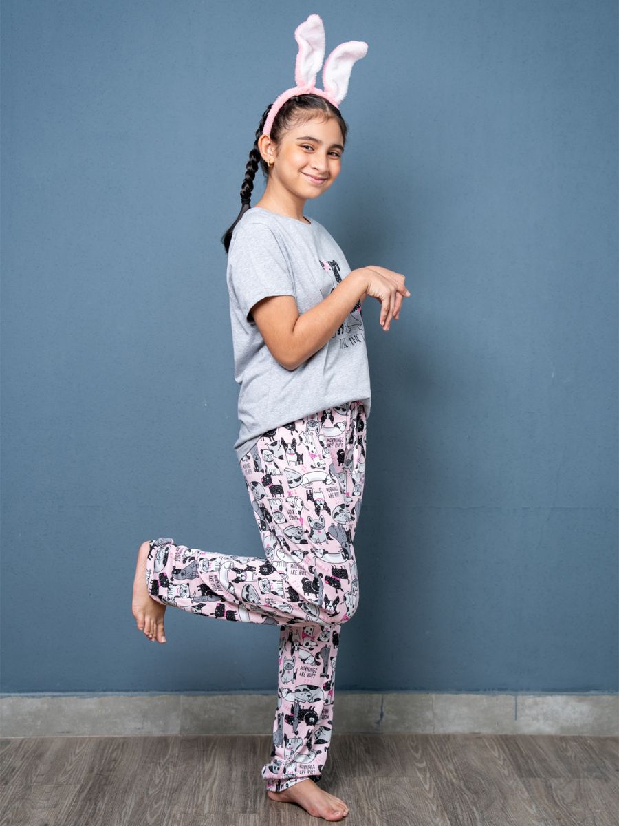 Girl in pajama set with bunny ears posing against a blue wall