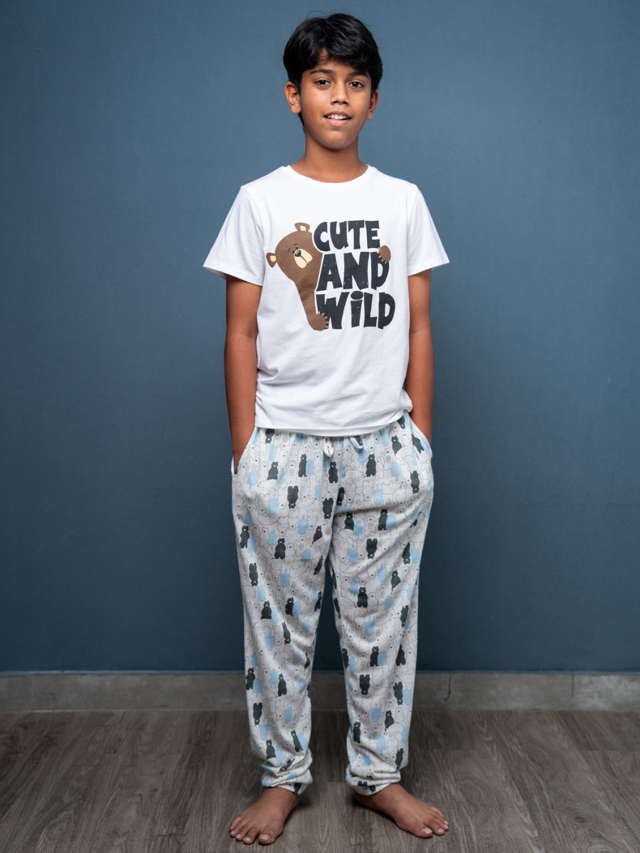 Child wearing a ‘Cute and Wild’ t-shirt and pajama set against a blue wall.