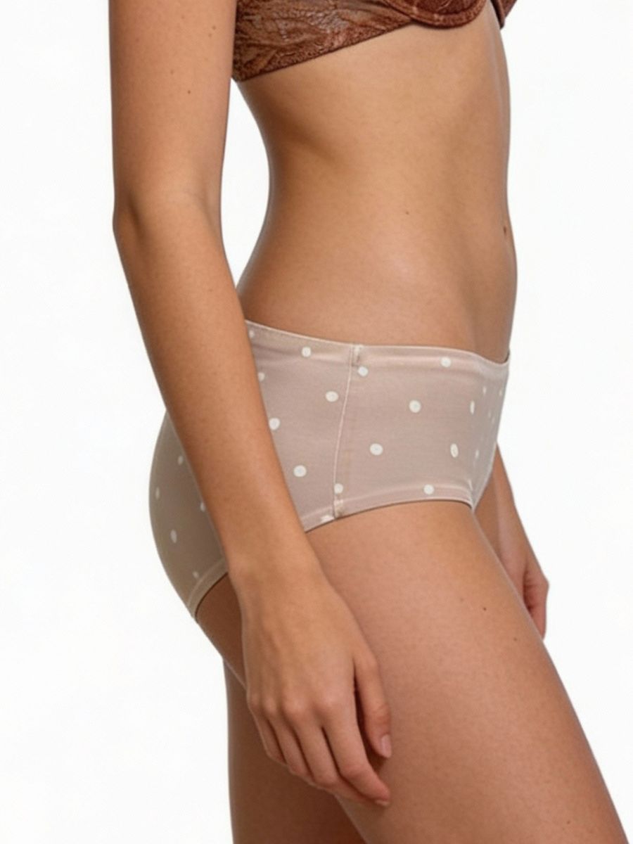 Beige polka dot underwear worn by a person on a white background