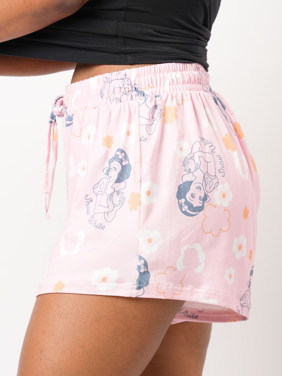 Pink shorts with character print worn by a person on a white background