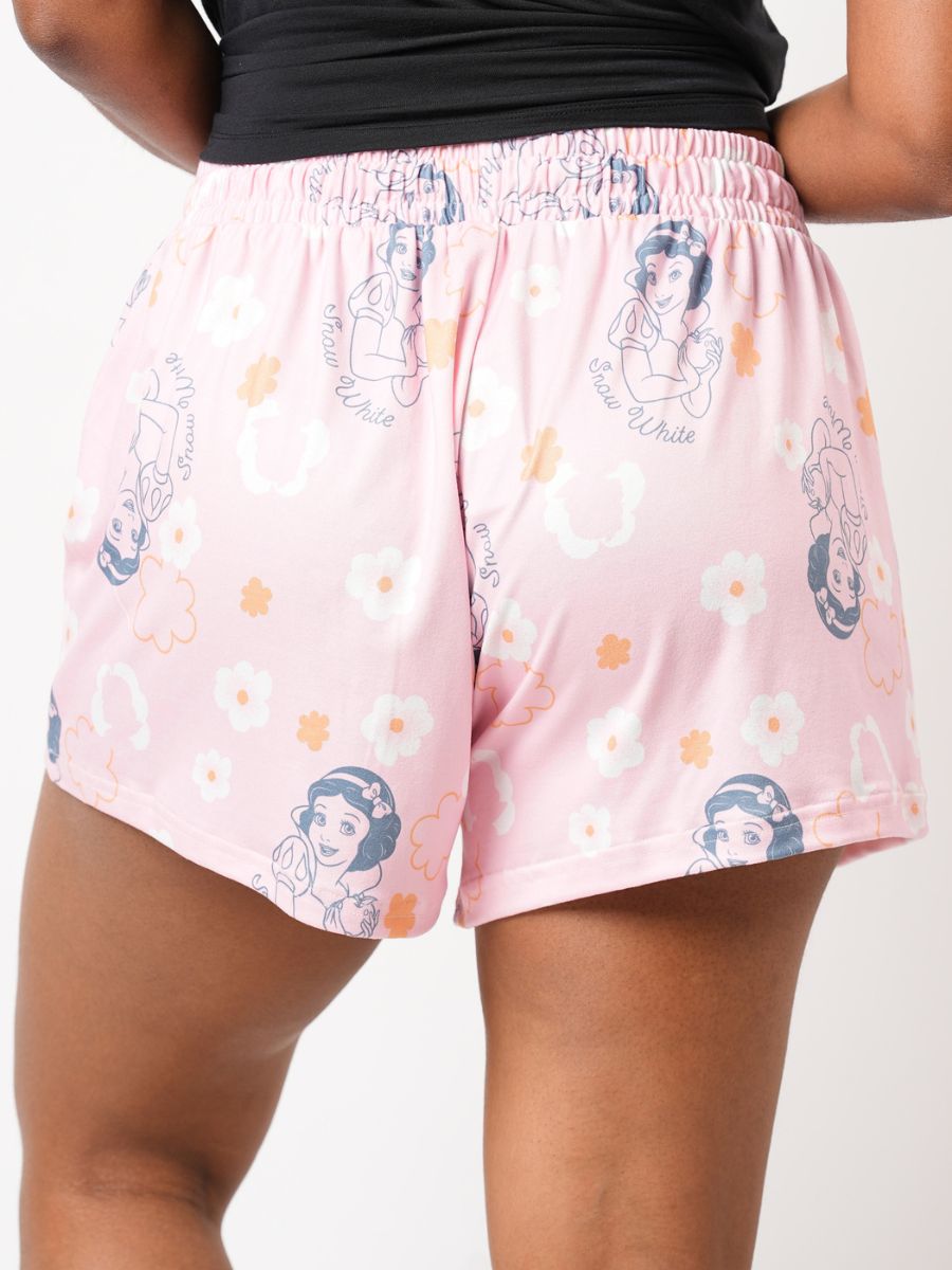 Pink shorts with character print worn by a person on a white background