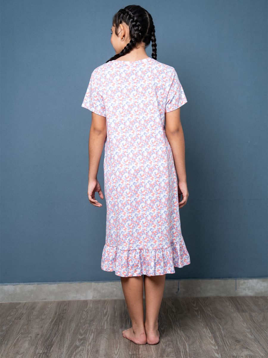 Person wearing a floral dress against a blue wall