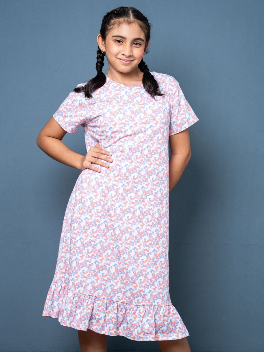 Young girl wearing a floral dress against a blue background
