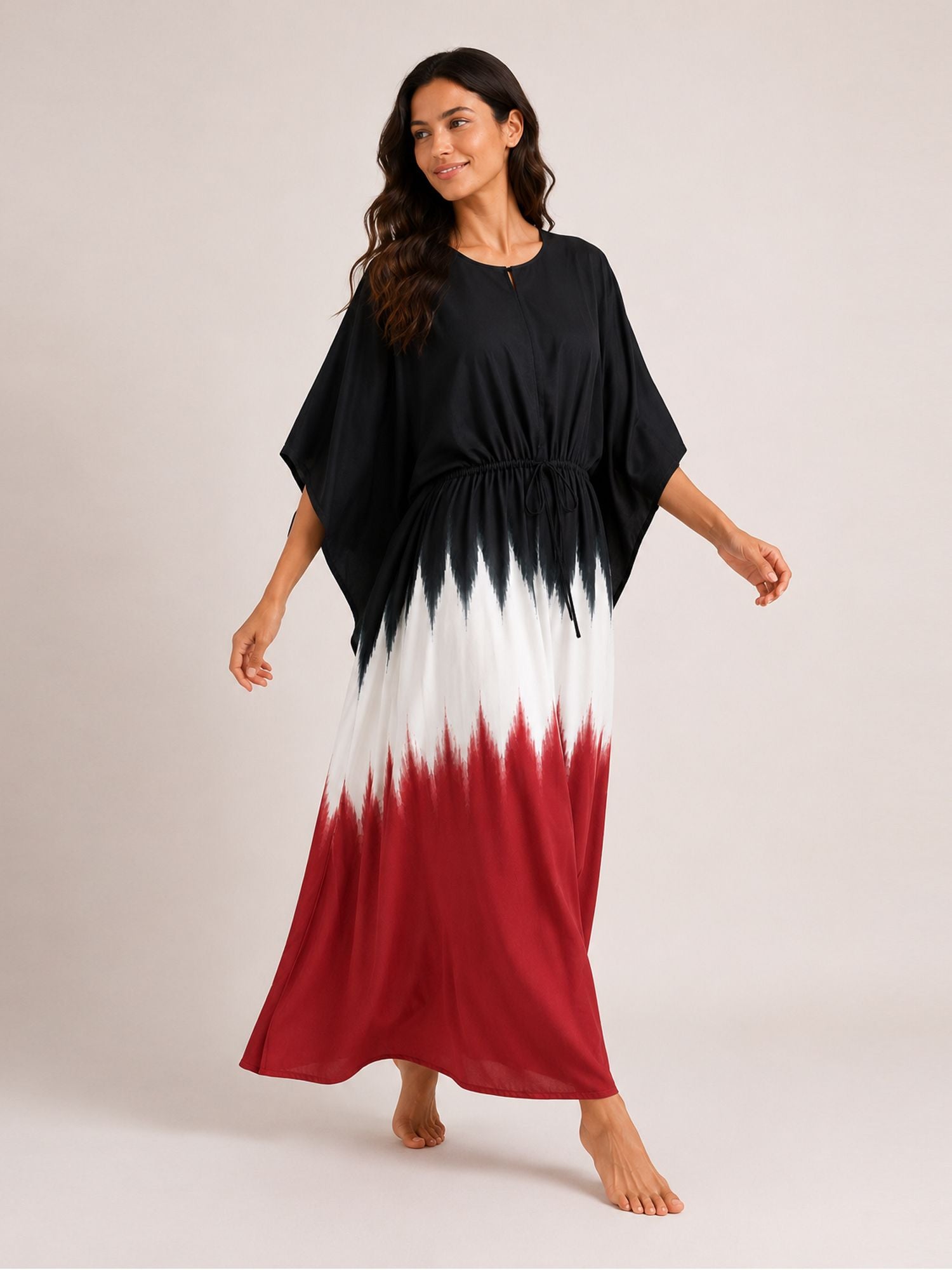 Woman wearing a black, white, and red dress on a plain background