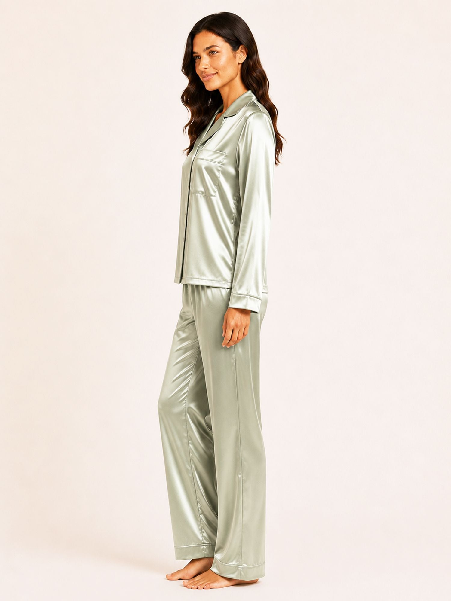 Woman wearing a silver satin pajama set on a white background