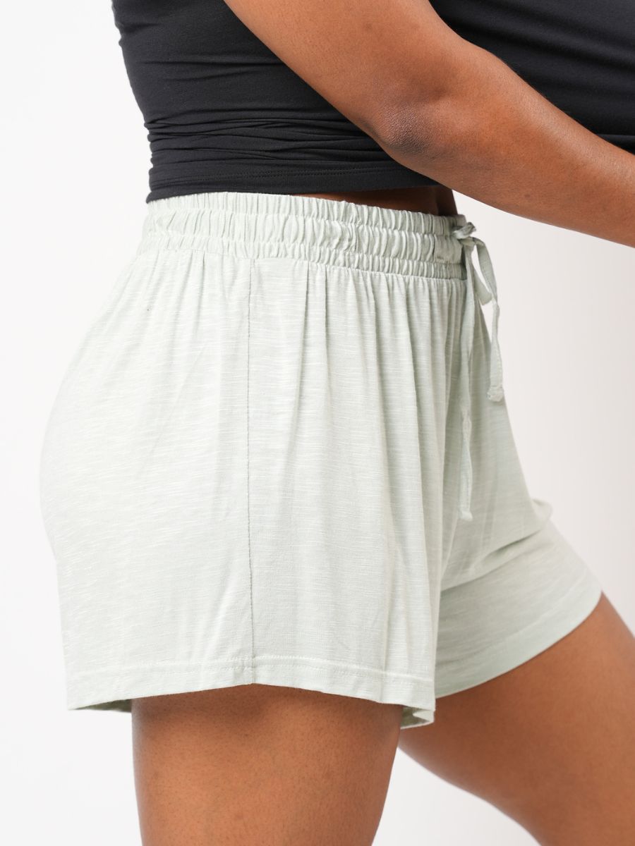 Light gray athletic shorts worn by a person on a white background