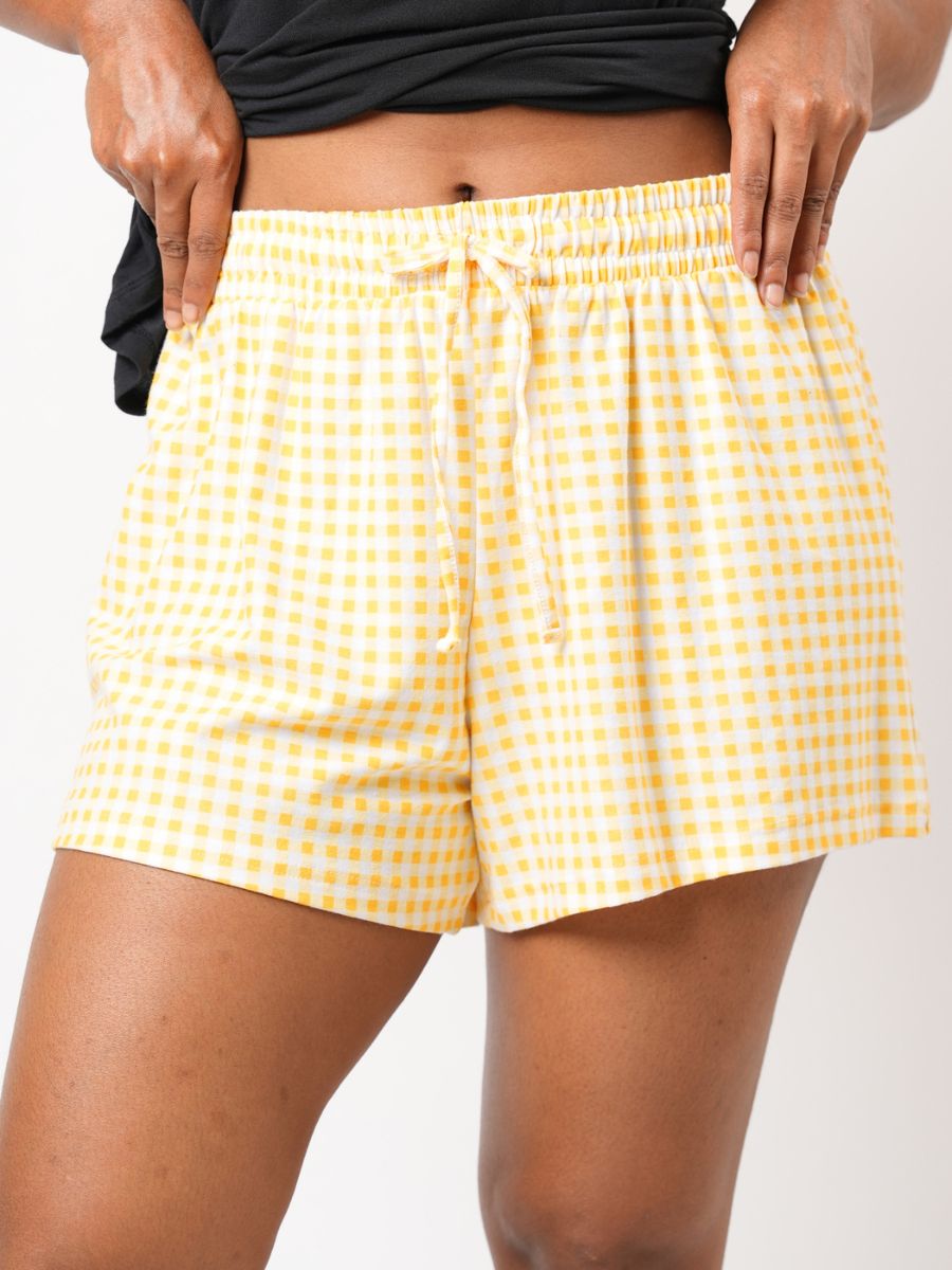 Yellow checkered shorts worn by a person on a white background